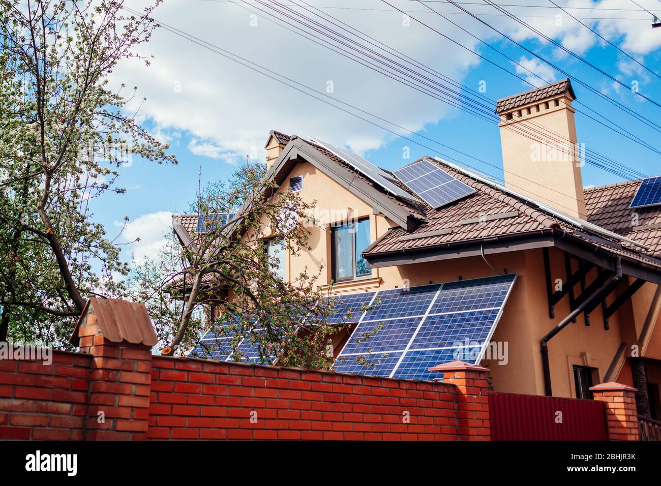 Residential house with solar panels on roof. Alternative energy. Using
