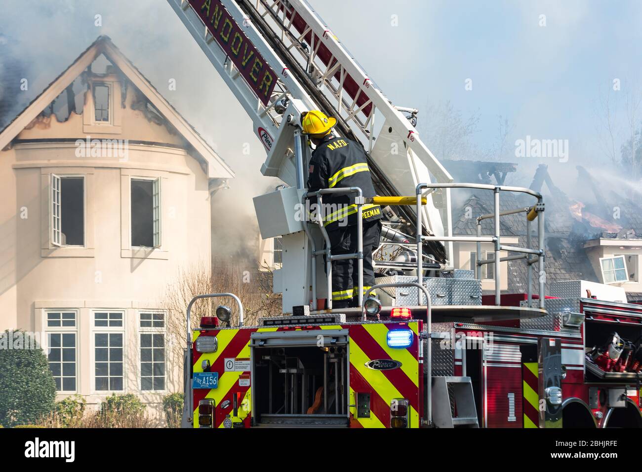 Firefighter on fire truck battling fire at 84 Castlemere Place, North