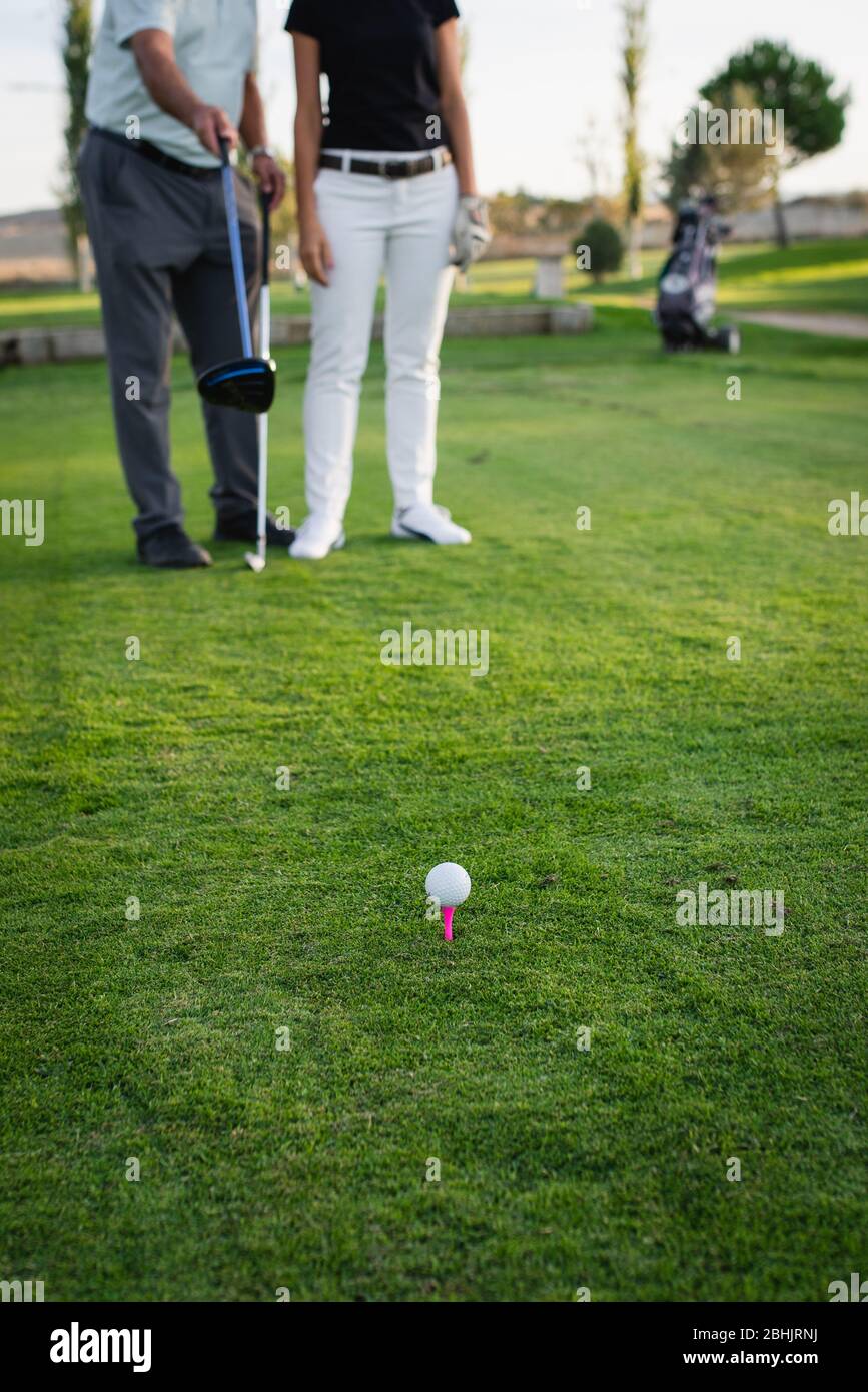 Tee with golf ball on green course Stock Photo