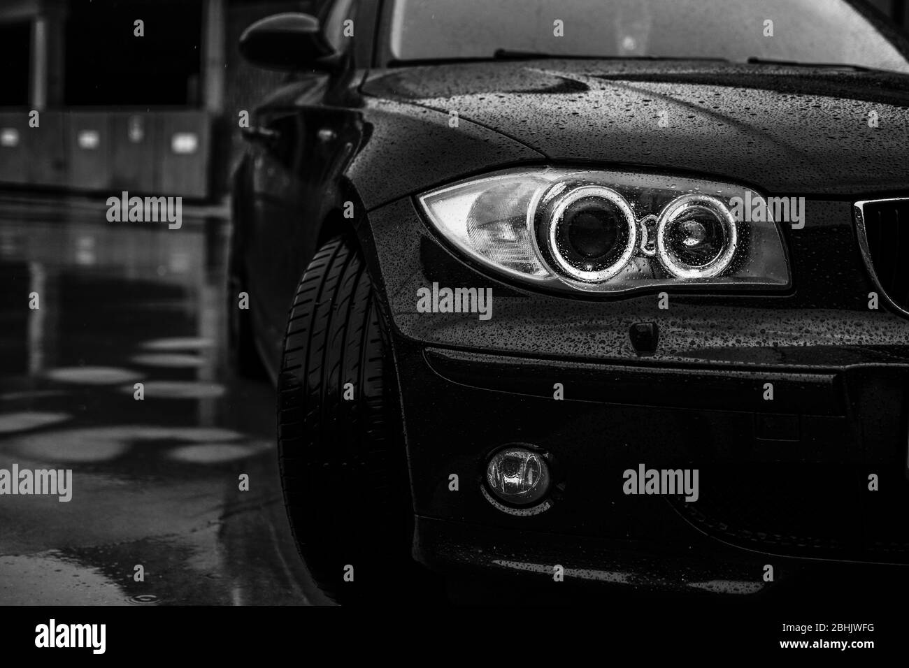Headlamps of the BMW 120d in rain. Stock Photo