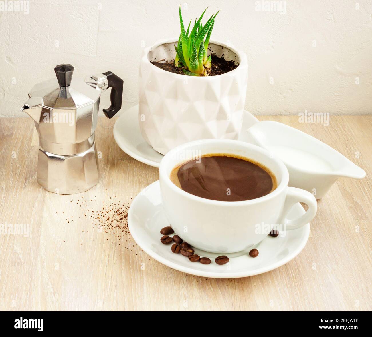 Cup of coffee, saucer and beans, aluminum coffee maker, milk container