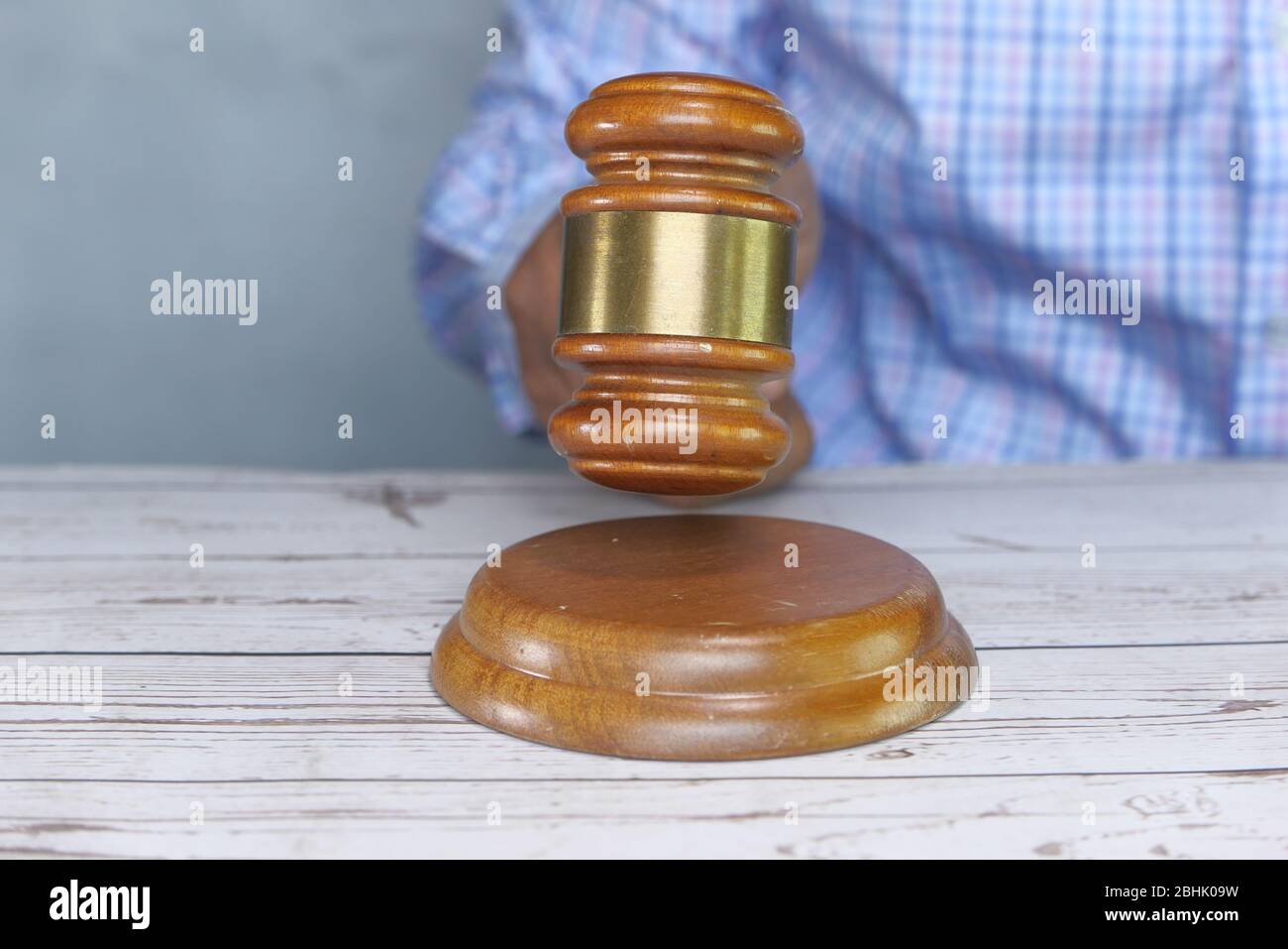 Judge Hand Banging the Gavel on Court Room Table. Stock Photo