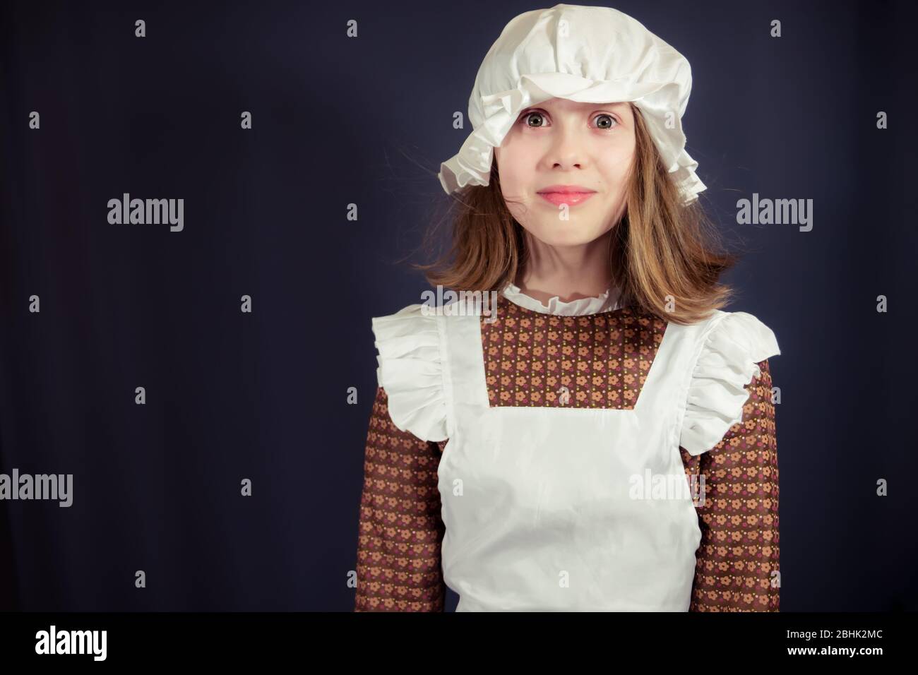 Girl in Victorian maid costume with face showing shock, surprise - with white space Stock Photo