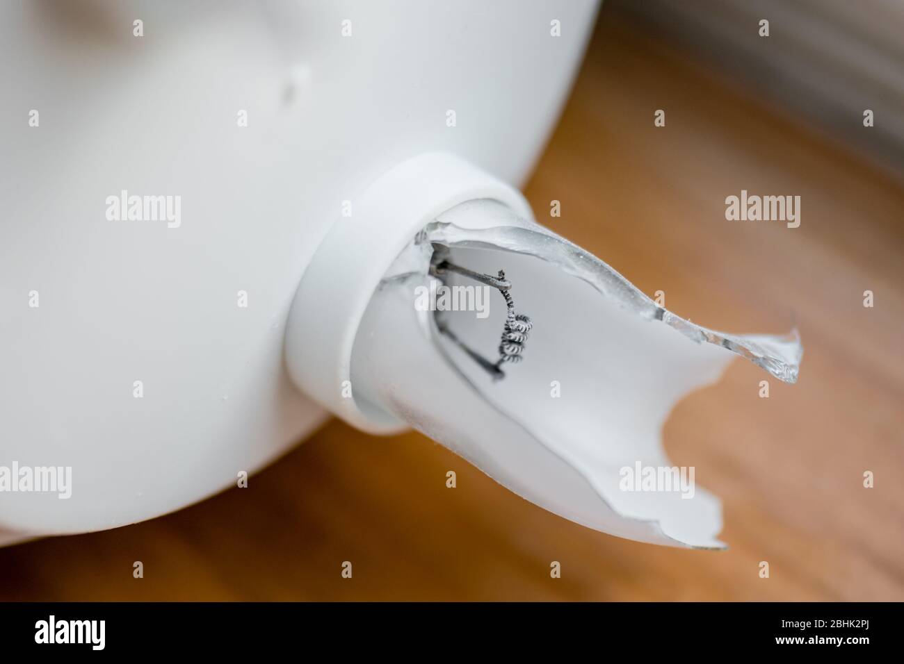 An exposed electrode and phosphor coated glass in a broken compact