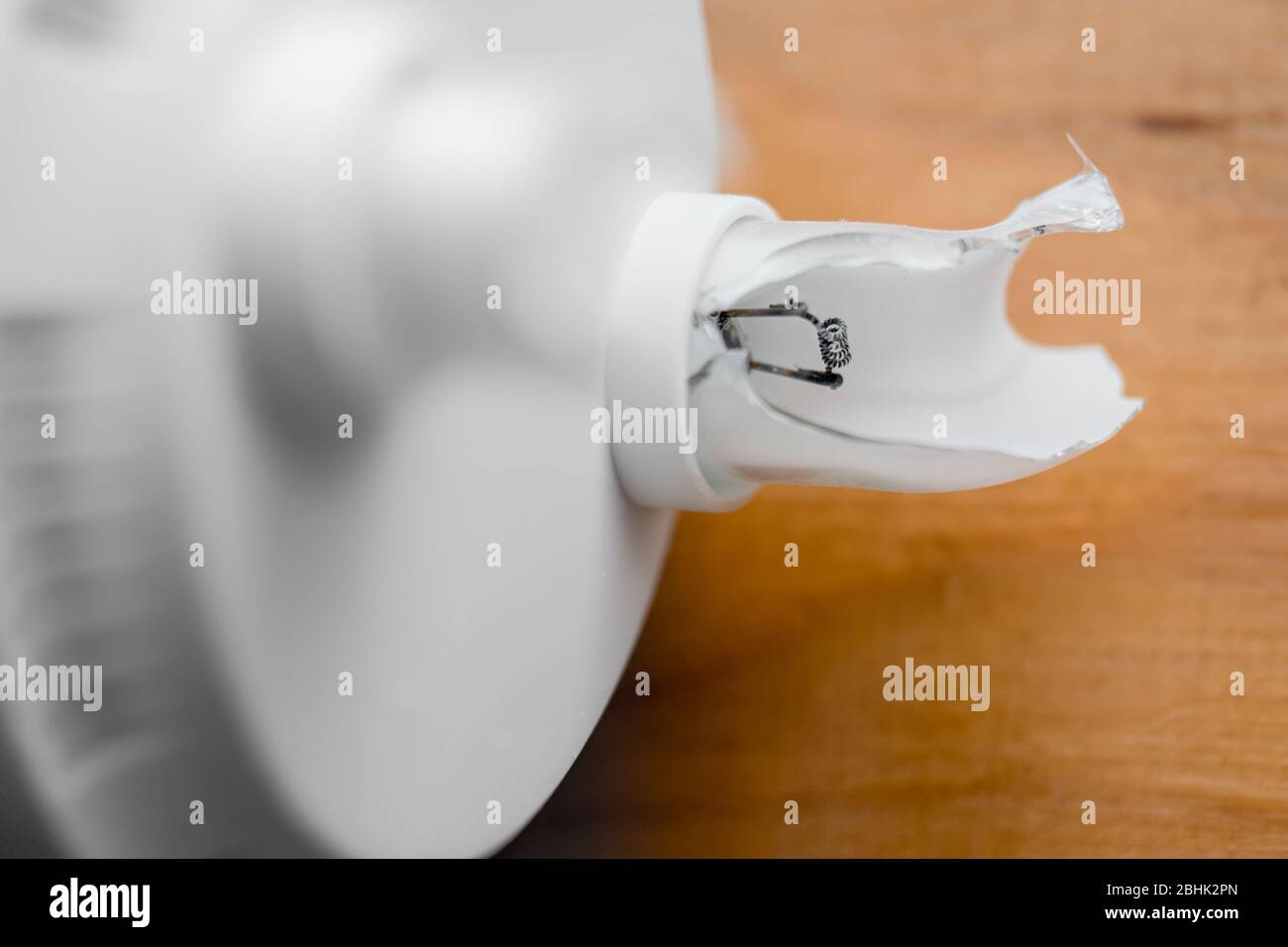 An exposed electrode and phosphor coated glass in a broken compact