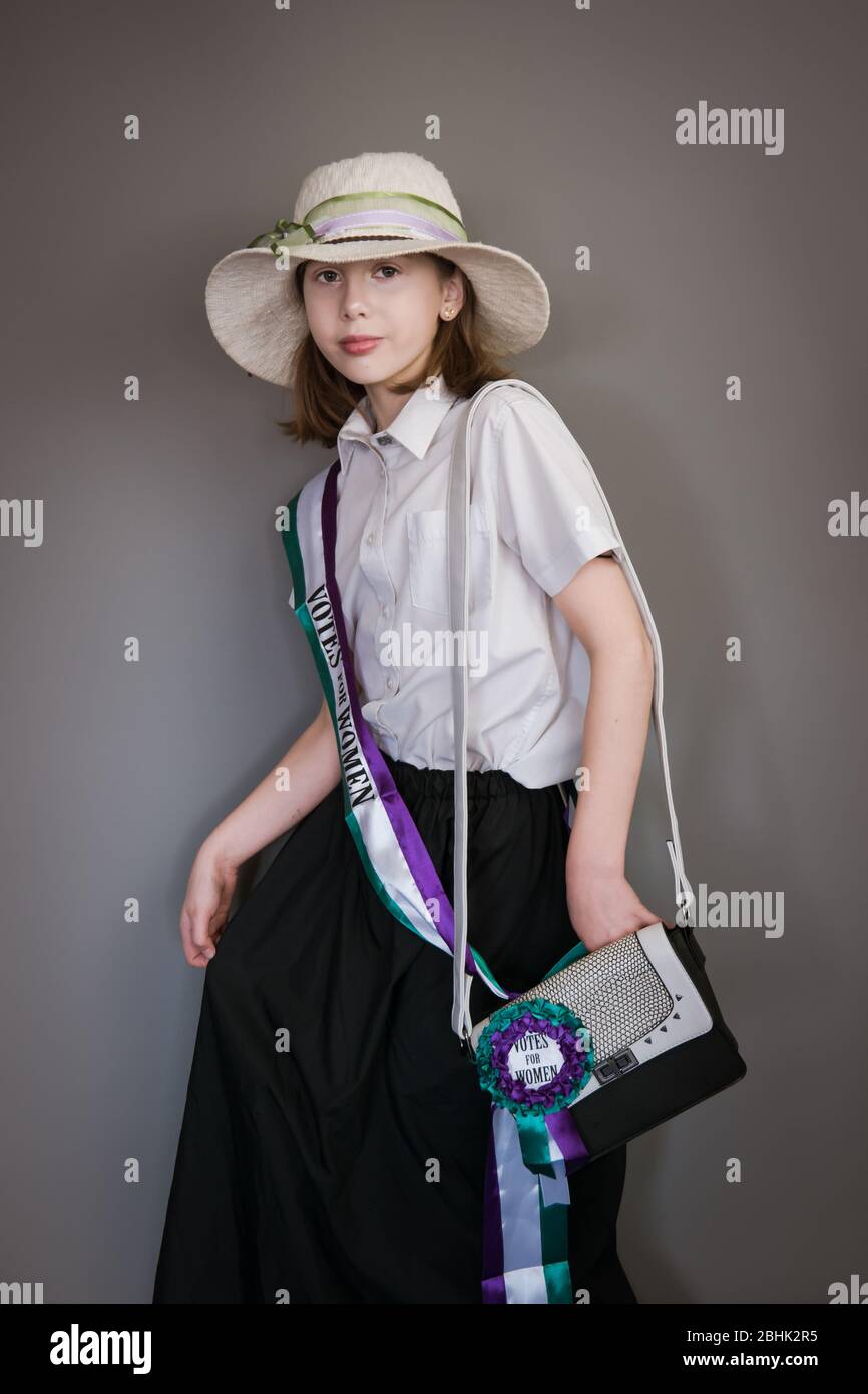 A vintage styled portrait of a girl in a suffragette costume with sash and hat Stock Photo