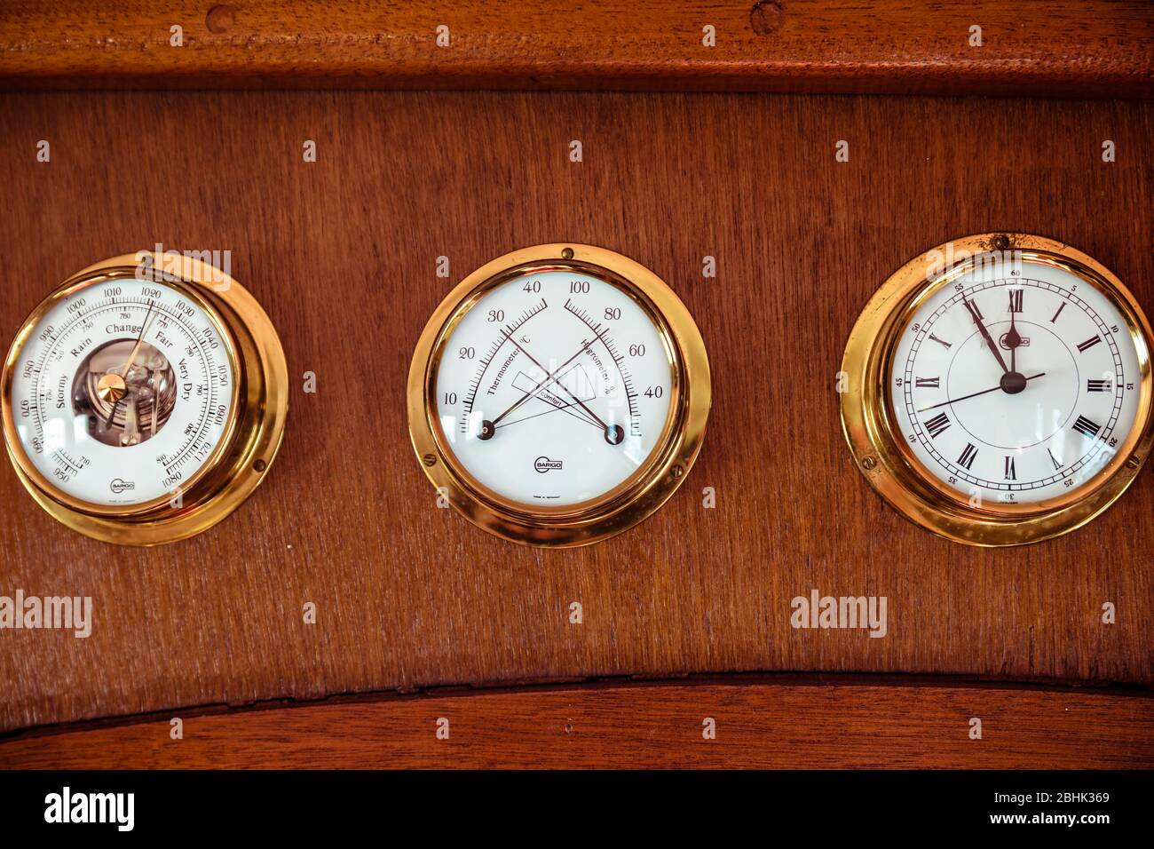 A trio of Barigo nautical instruments, barometer thermometer hygrometer clock, on a vintage boat Stock Photo