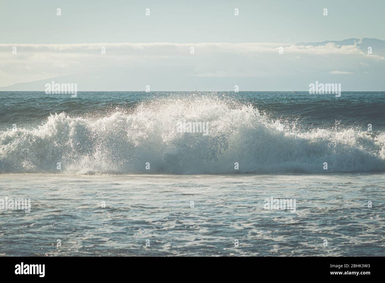 A single powerful wave crashing in the sea or ocean Stock Photo