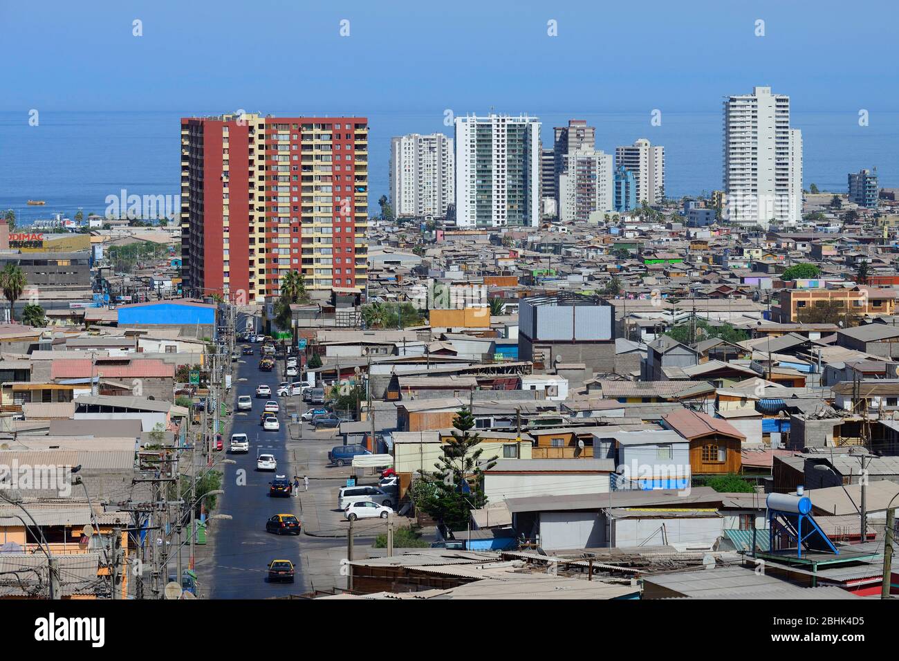 Typical simple residential buildings in front of skyscrapers, Iquique, Tarapaca region, Chile Stock Photo
