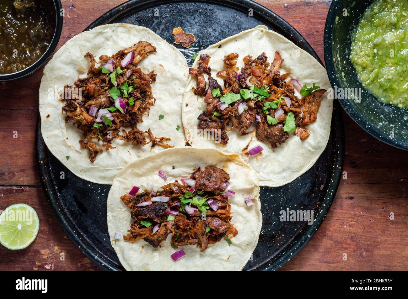 Carnitas tacos with red onion and raw green salsa Stock Photo Alamy