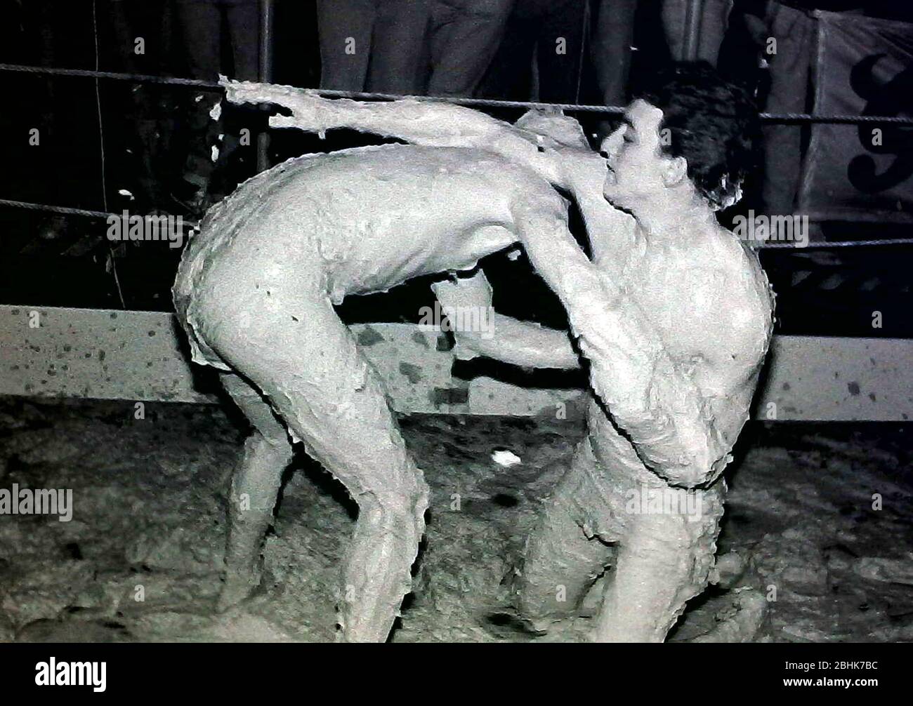 Two young men mud wrestling in Heros club in Manchester, England, United Kingdom, a popular club for gay male customers, in 1984. Daily life in the night life of Manchester's gay clubs and bars in the 1980's. Stock Photo