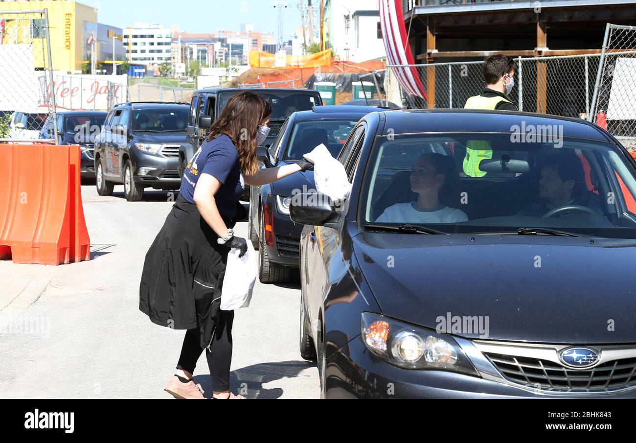 St. Louis, United States. 26th Apr, 2020. A volunteer hands off a bag of prepared sandwiches, to one of many that have waited in their cars for free food, in St. Louis on Sunday, April 26, 2020. Hundreds of cars lined the streets for an opportunity to receive food from several restaurants, while the group took donations for the The Gateway Resilience Fund, an organization that assists fellow restaurant workers that are out of work because of the coronavirus. Photo by Bill Greenblatt/UPI Credit: UPI/Alamy Live News Stock Photo
