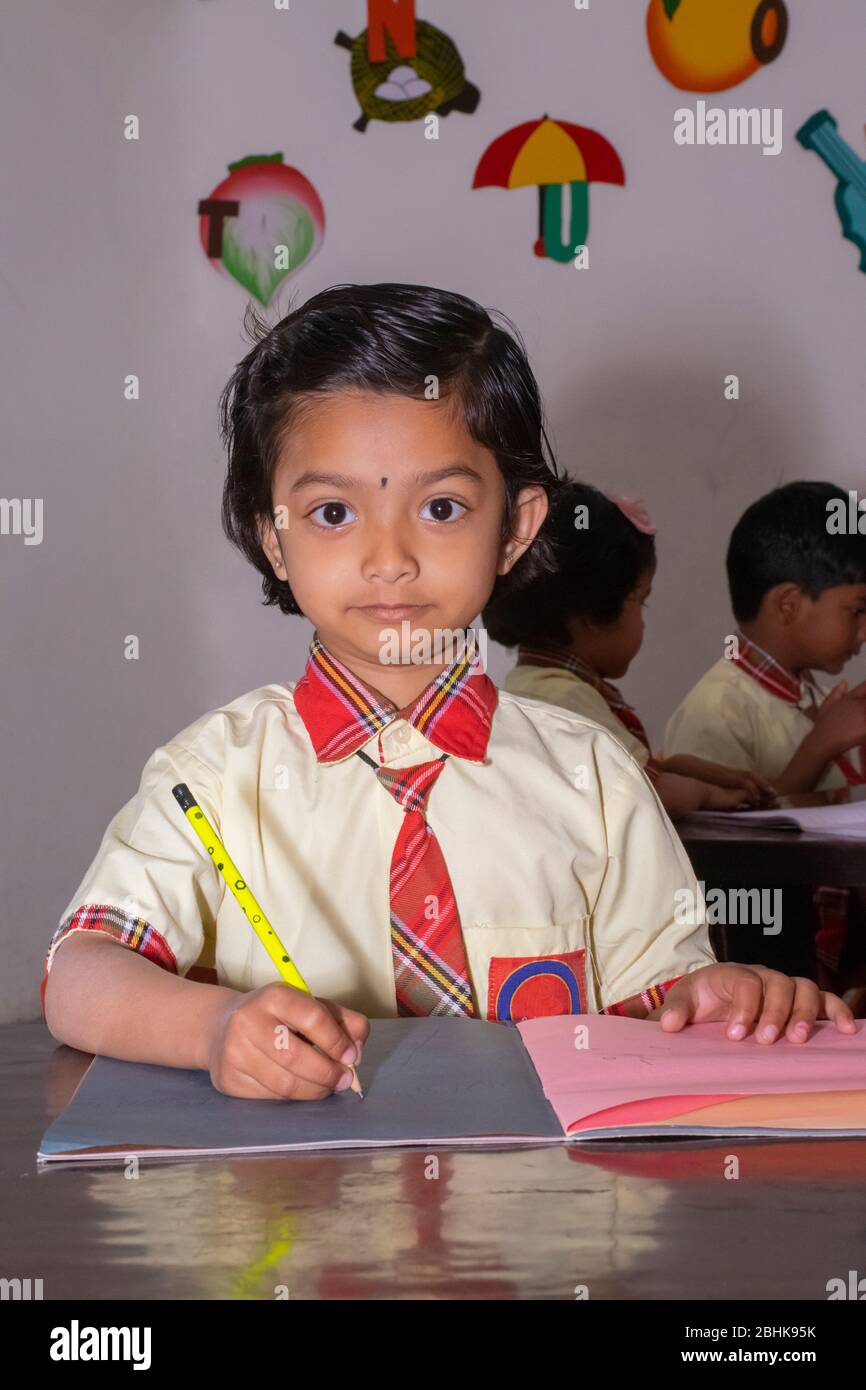 Young primary or elementary school children sitting at their desks in a classroom, India Stock Photo