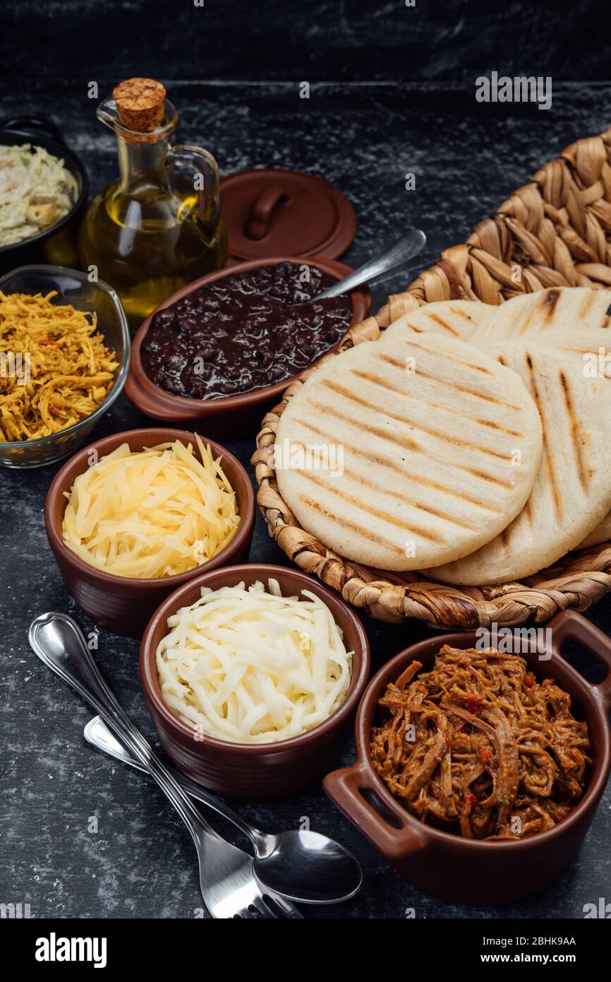 Top view of typical Latin American food. Group of arepas and different types of ingredients to fill them Stock Photo