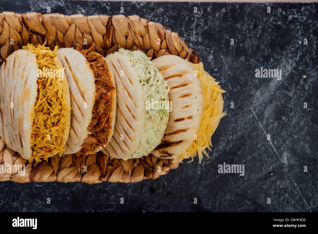 Top view of various types of typical Venezuelan arepas in a woven basket Stock Photo