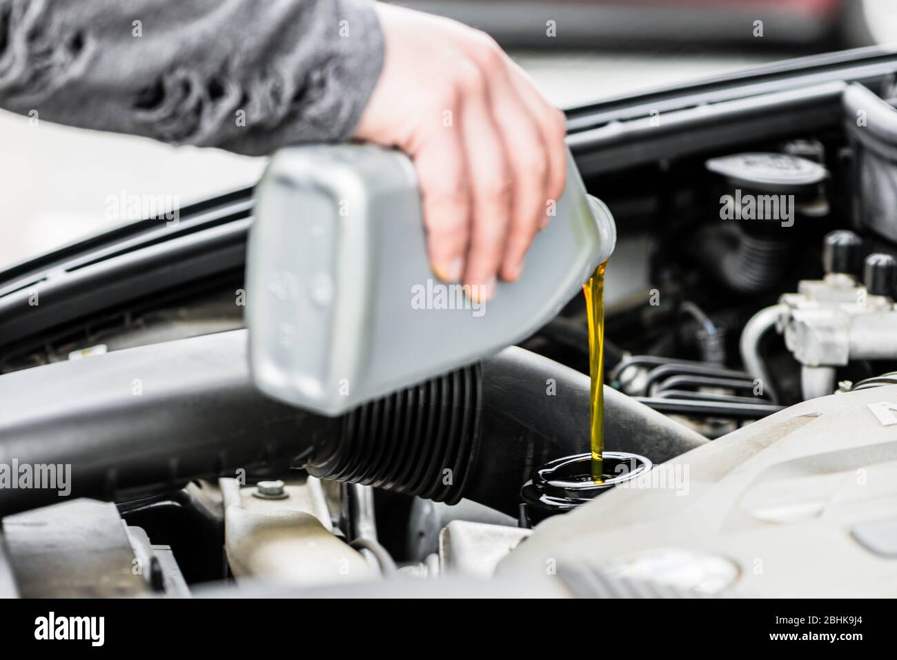 Woman putting oil into the engine of her car Stock Photo Alamy