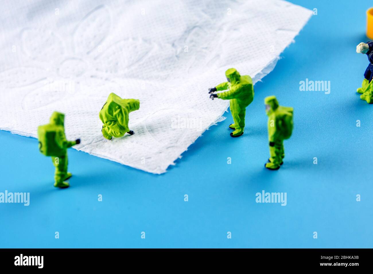a team of miniature figurines checking a cleanliness of toilet paper, very important to make a desinfection of lavatory and other possibly dirty place Stock Photo