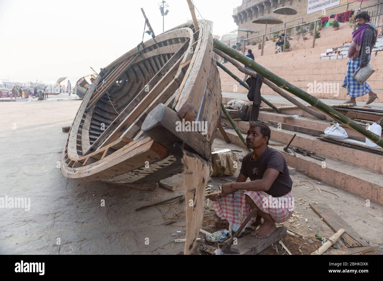 A shipwright builds a boat for a living near Ganges river bank in Varanasi, India Stock Photo