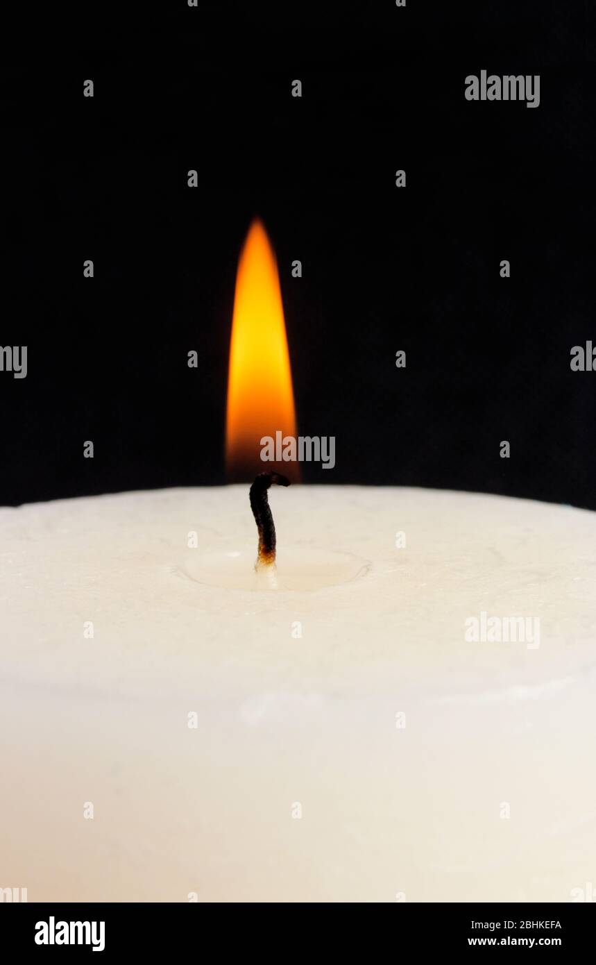Burning paraffin candle close-up isolated on black Stock Photo