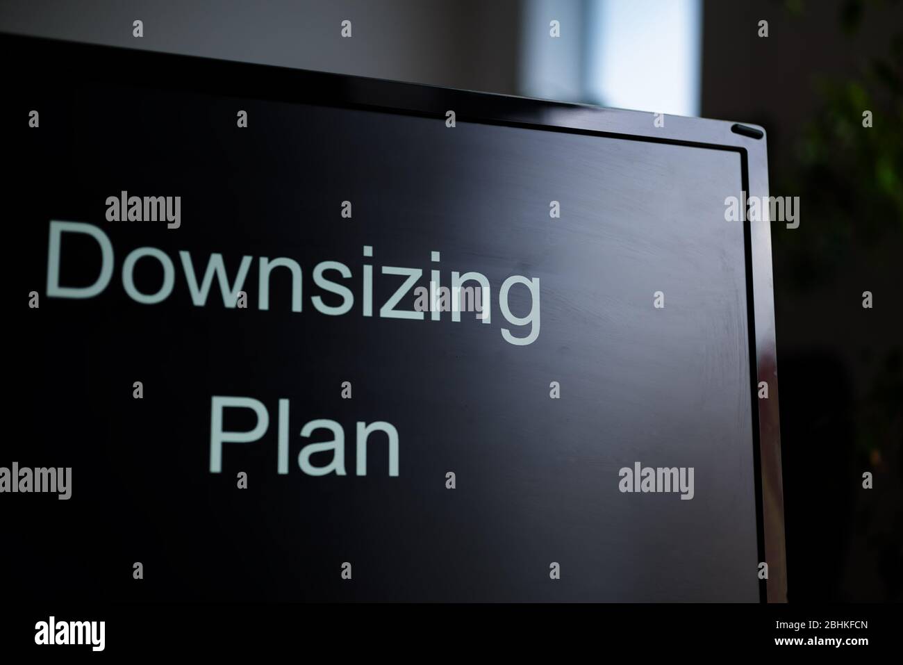 The PC monitor with a text Downsizing plan on the screen. Crisis staff reduction concept. Anti-crisis actions. Stock Photo