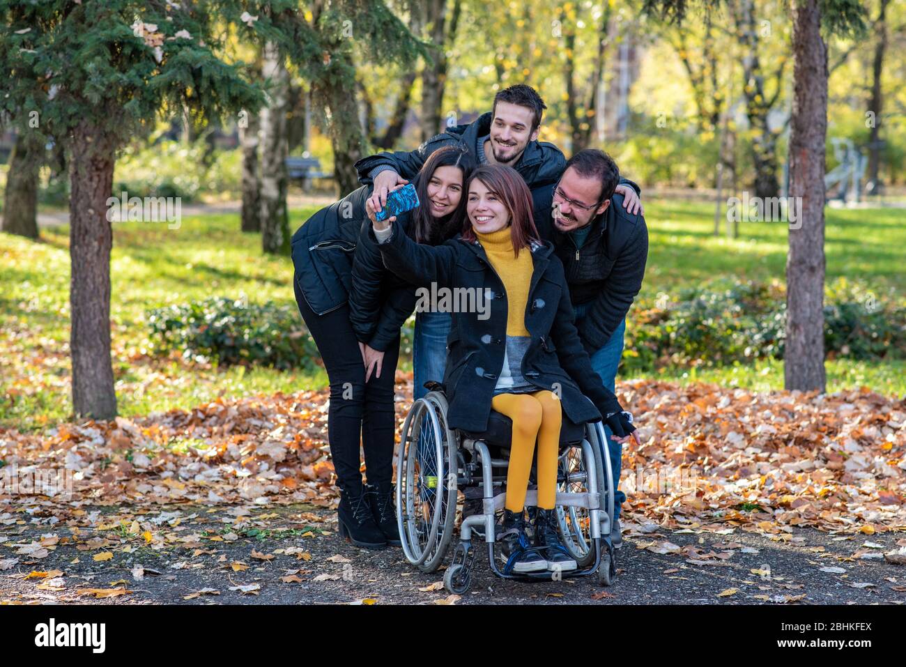 Young disabled woman in a wheelchair taking selfie with friends in a ...