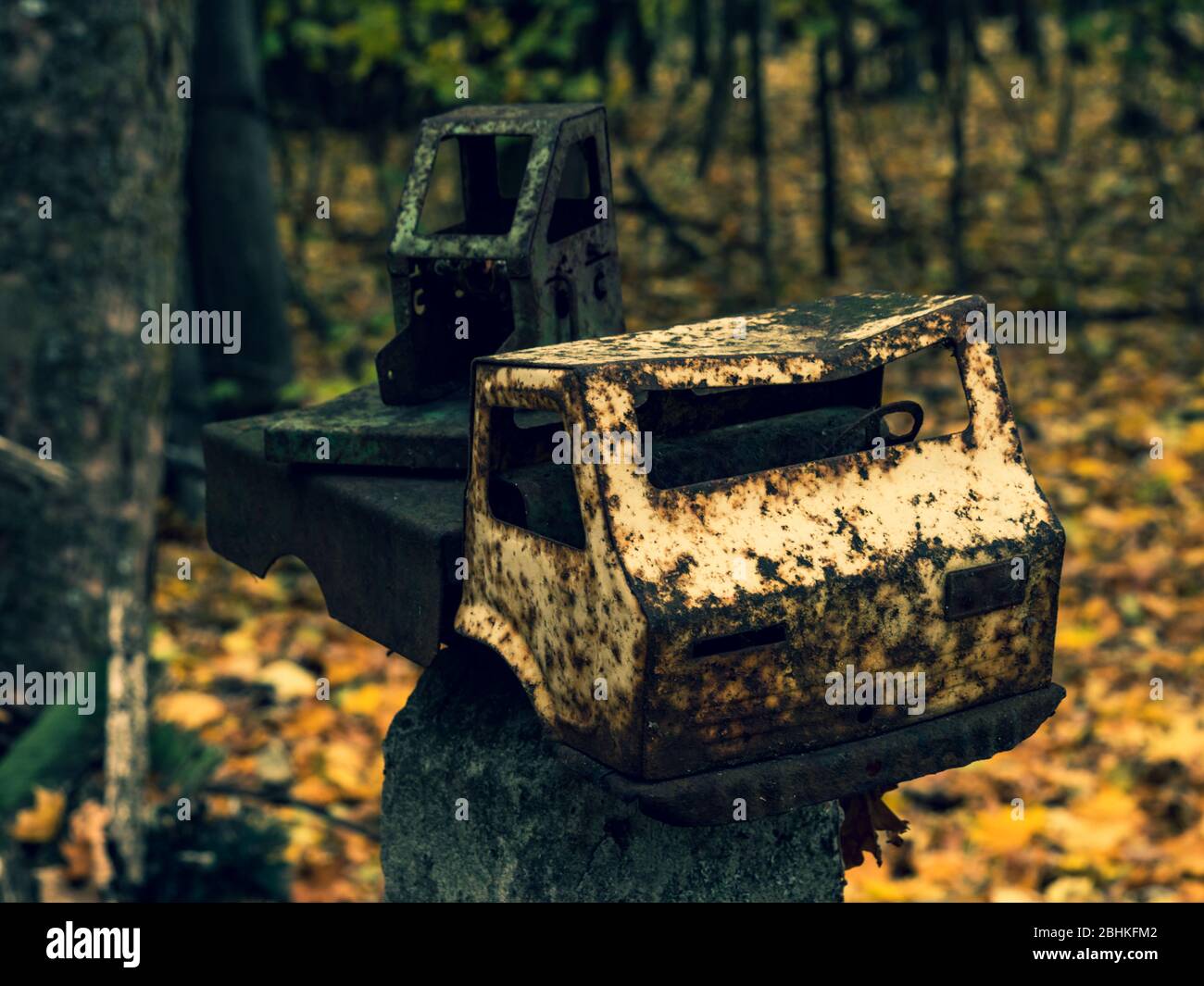 Broken rusty toy truck on fence post at abandoned kindergarten in