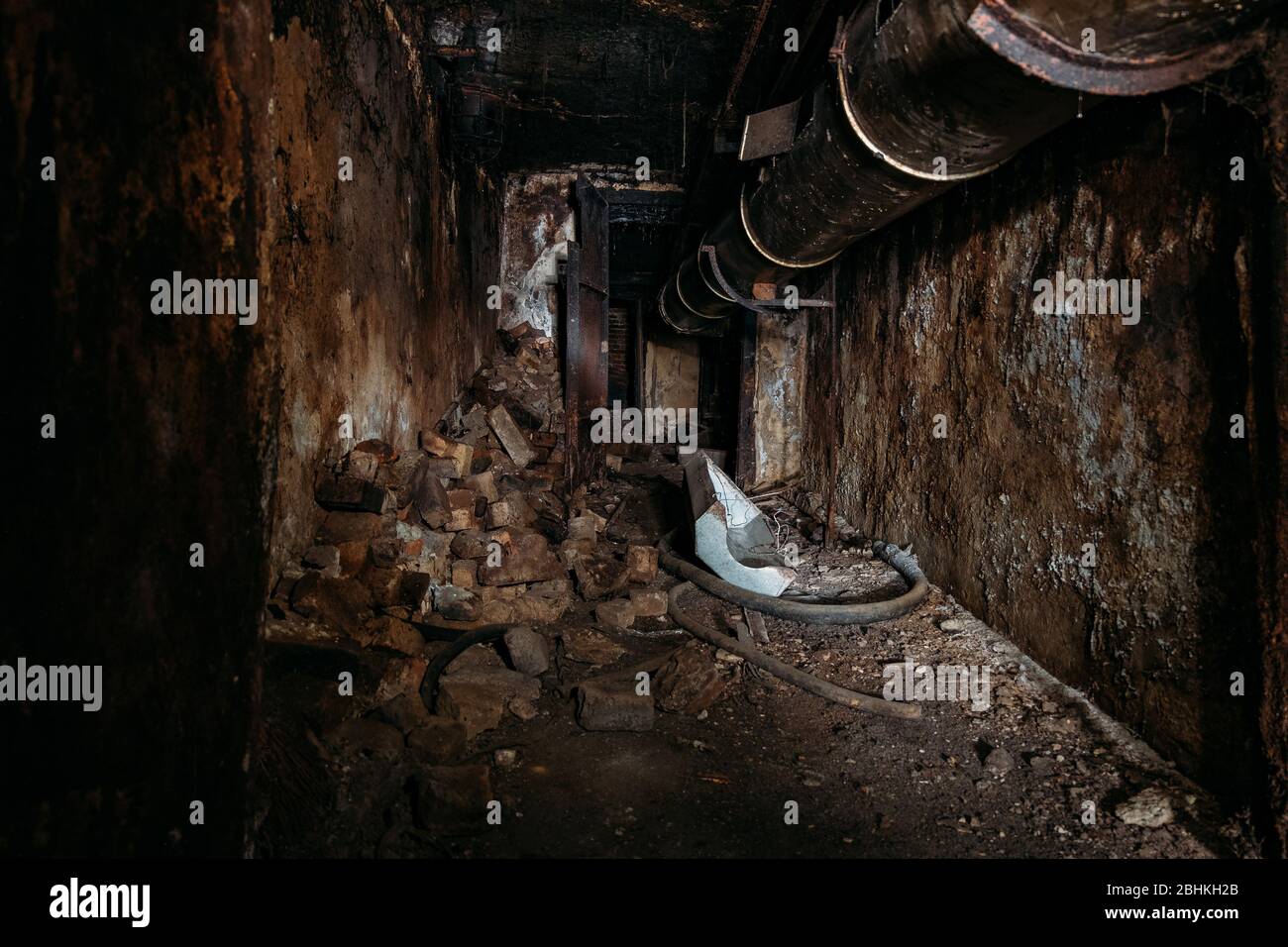 Burnt interior of industrial building basement. Walls in black soot after fire. Stock Photo