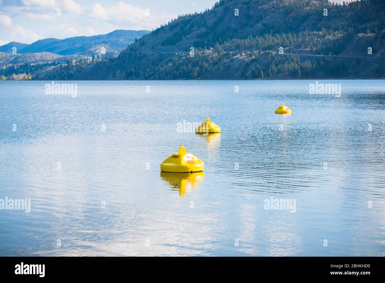 Yellow buoys marking hazardous area with dangerous under currents on lake, where swimming is not permitted Stock Photo