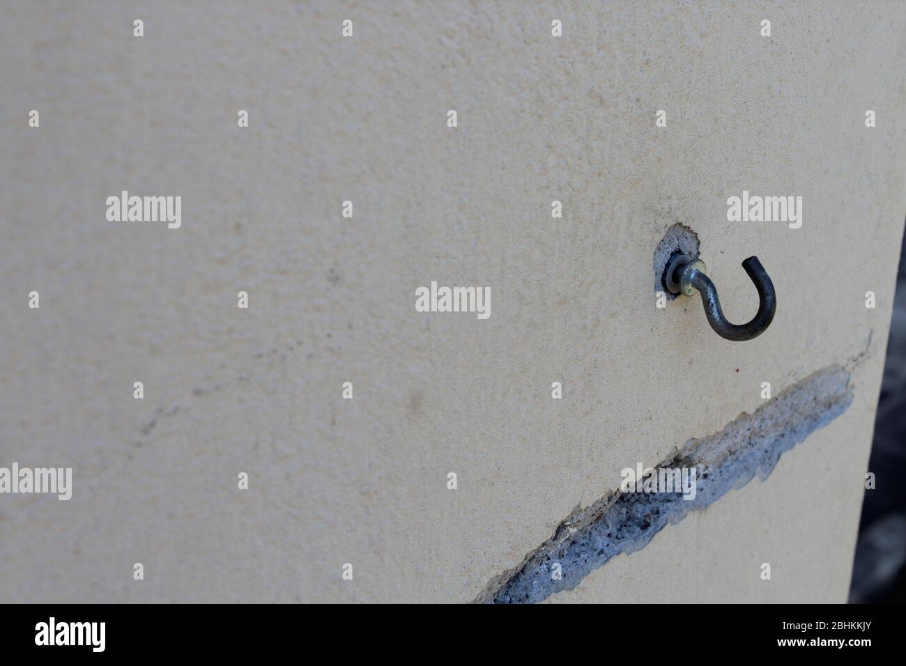 rusty hook on a painted garden wall Stock Photo