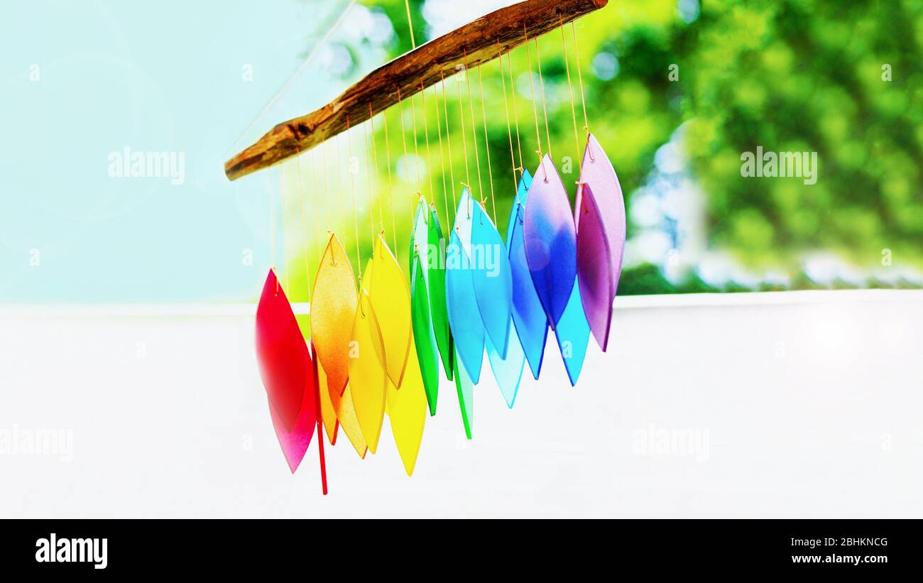 Rainbow glass wind chimes or windchime on nature background. Feng shui symbol. Copy space, 16:9 format Stock Photo