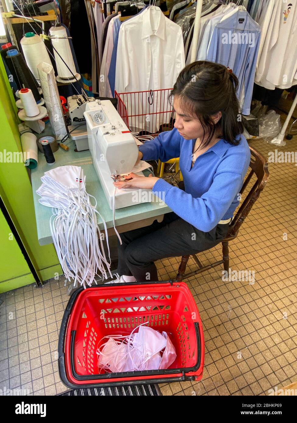 A VIETNAMESE FAMILY IS MAKING FACIAL MASKS DURING THE PARISIEN LOCKDOWN IN HIS CLOSED DRY-CLEANER Stock Photo