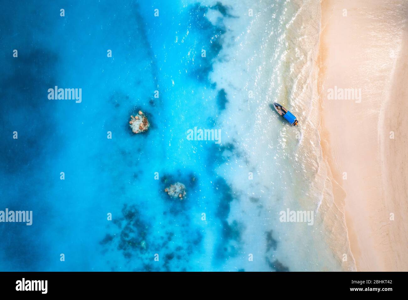 Aerial view of the fishing boat in clear blue water at sunset Stock ...