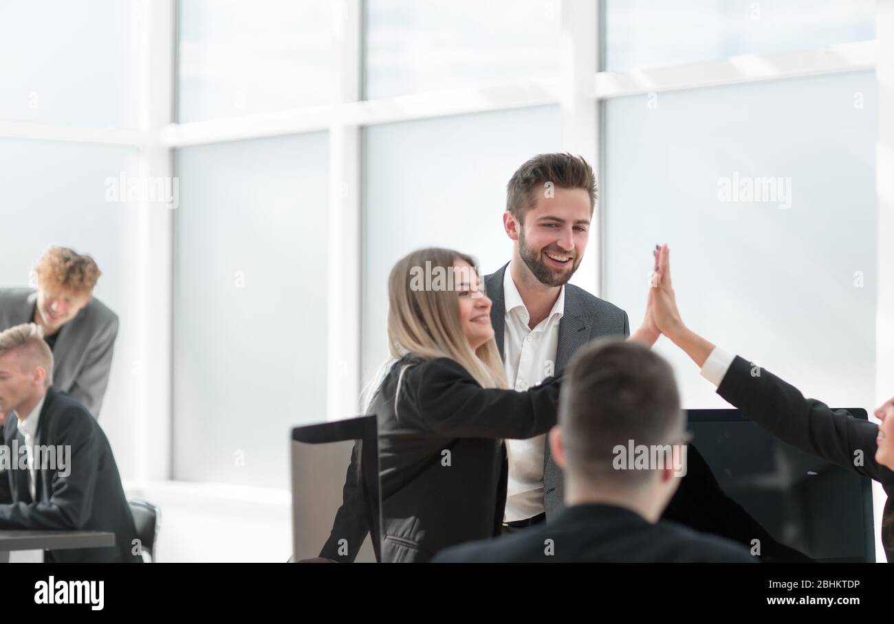 happy employees giving each other a high five Stock Photo - Alamy