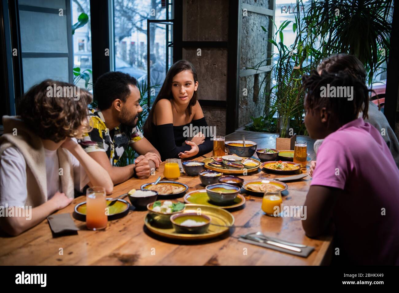 A group of friends sitting at the table in a cafe, chatting, having a nice  time Stock Photo - Alamy