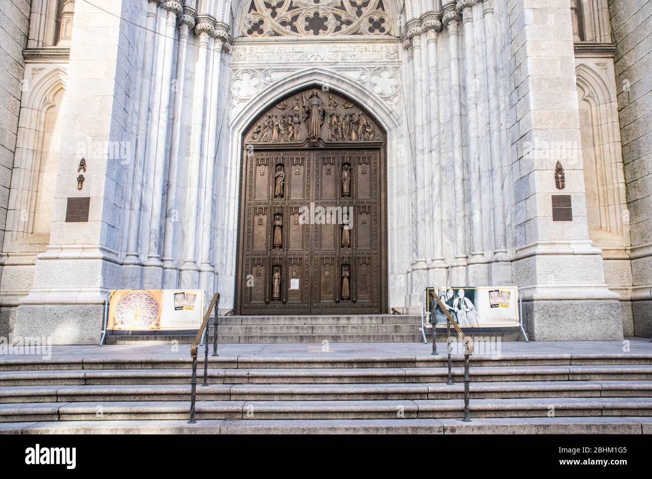 NEW YORK CITY - APRIL 19, 2020:  St. Patrick's Cathedral in midtown Manhattan stands empty with a sign on the doors during the Covid-19 Coronavirus pa Stock Photo
