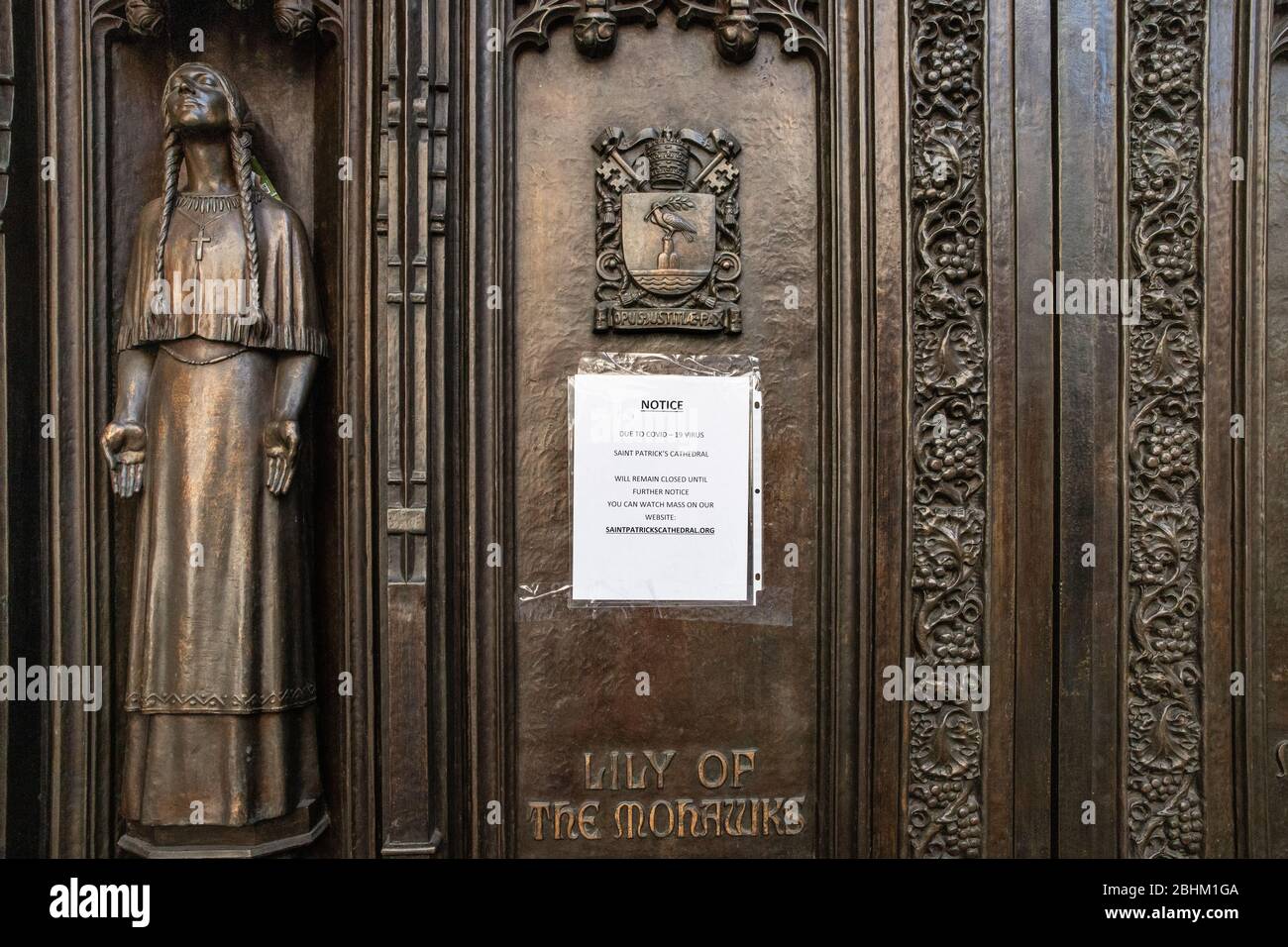 NEW YORK CITY - APRIL 19, 2020:  St. Patrick's Cathedral in midtown Manhattan stands empty with a sign on the doors during the Covid-19 Coronavirus pa Stock Photo