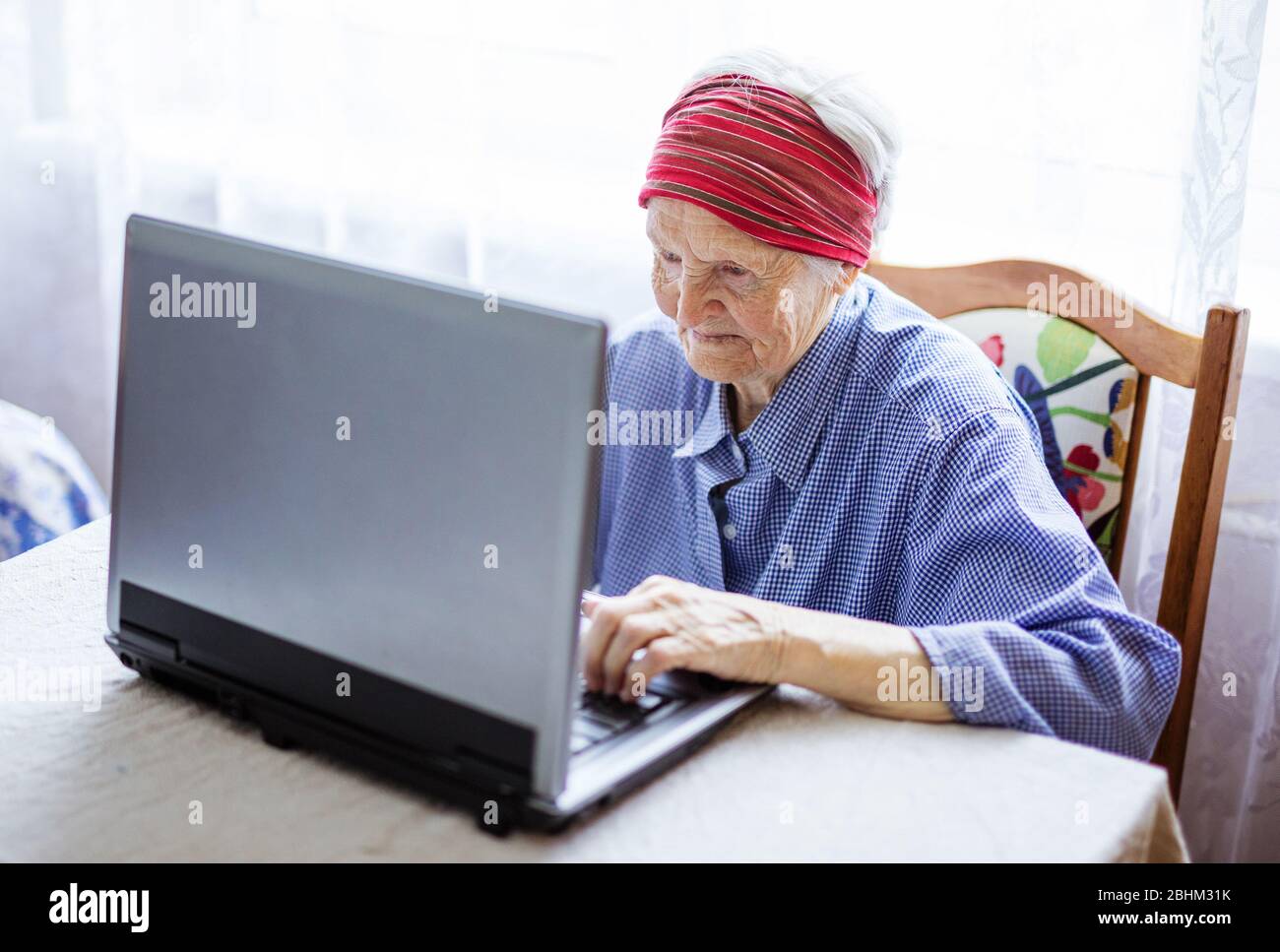 Senior woman using laptop computer at home Stock Photo