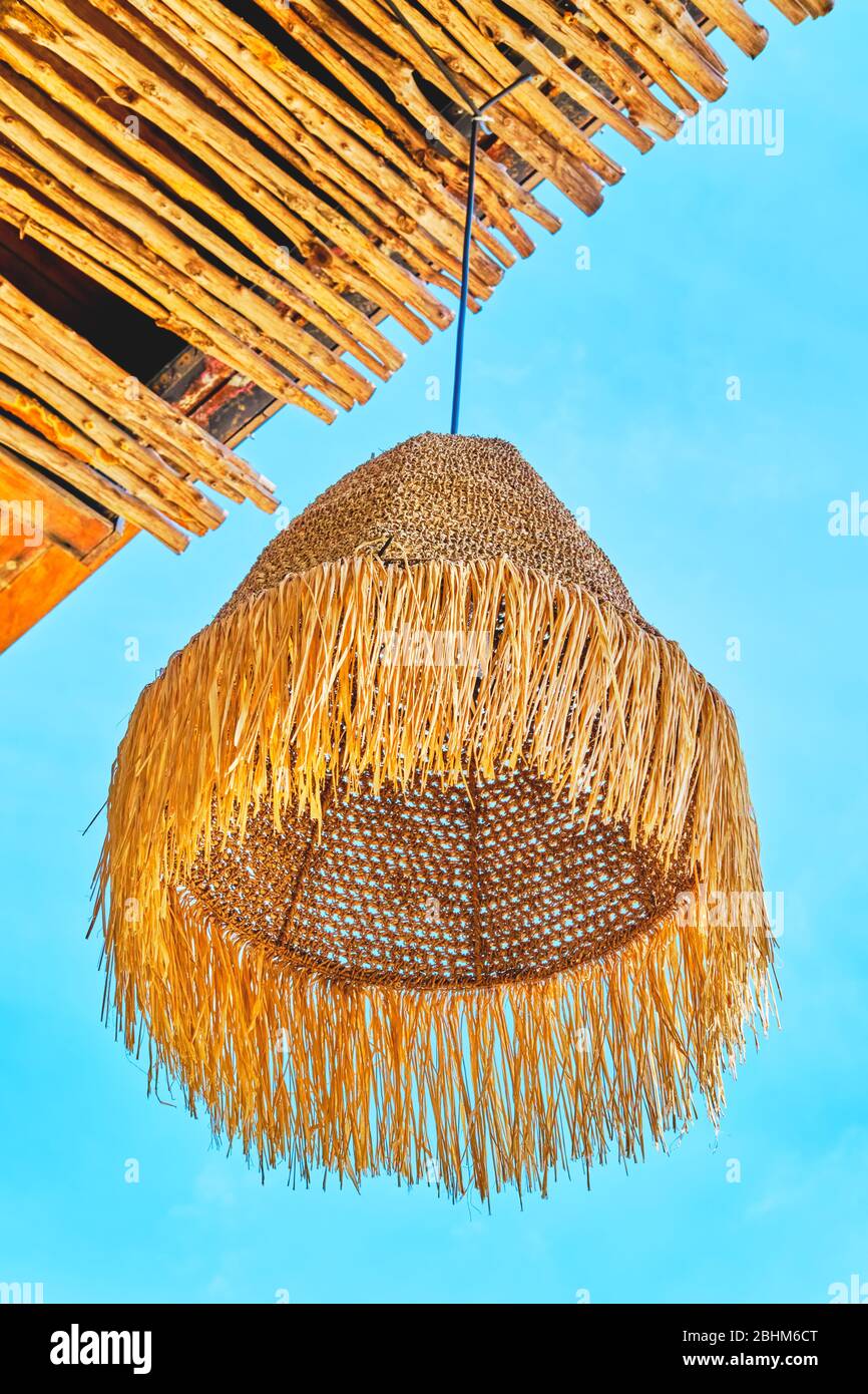 Decor rustic straw lamp at the beach patio, bar or shop with blue sky background. Vacation, get away, summer outing concept Stock Photo