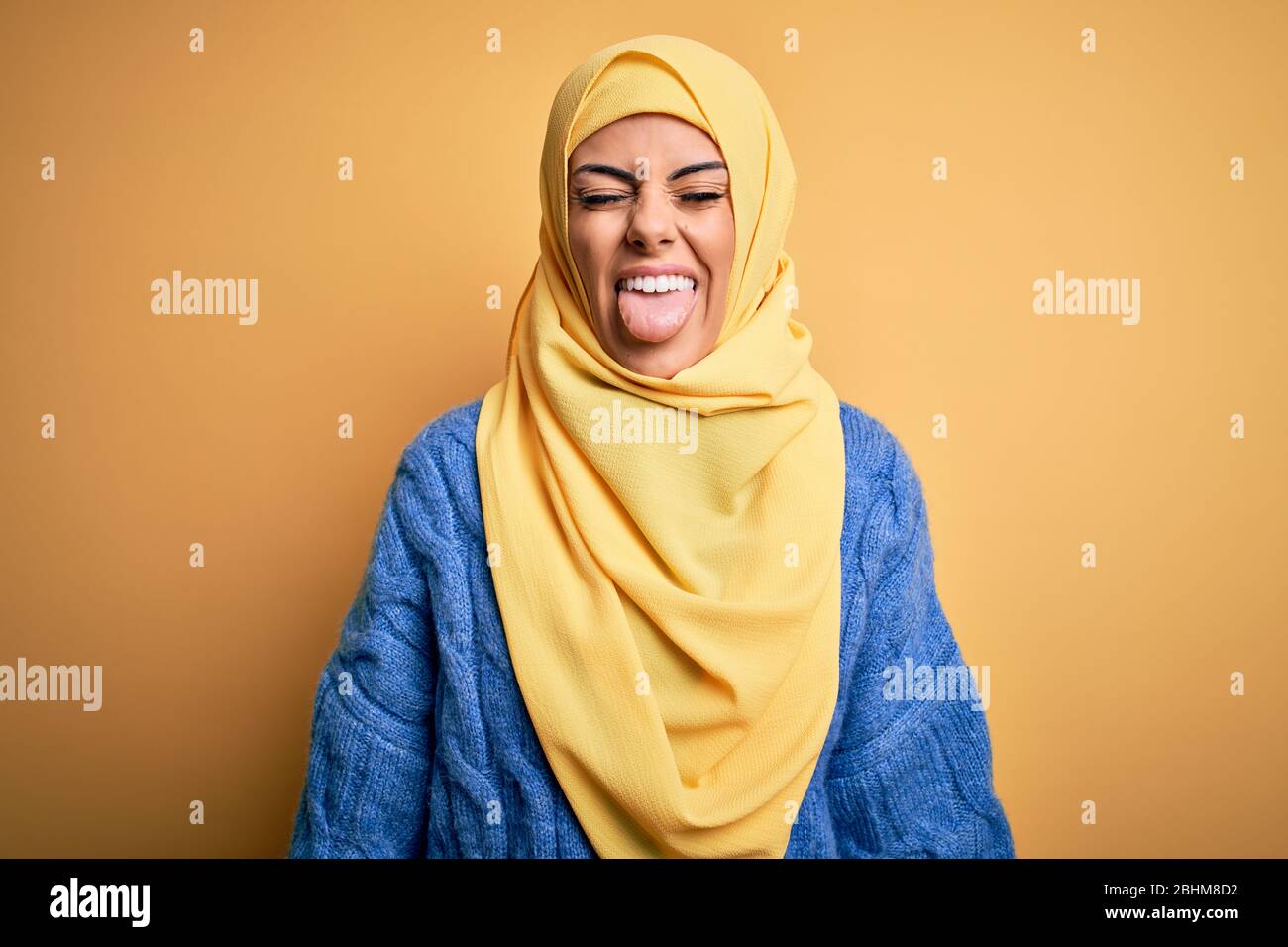 Young beautiful brunette muslim woman wearing arab hijab over isolated yellow background sticking tongue out happy with funny expression. Emotion conc Stock Photo - Alamy Young beautiful brunette muslim woman wearing arab hijab over isolated yellow background sticking tongue out happy with funny expression. Emotion conc Stock Photo - Alamy