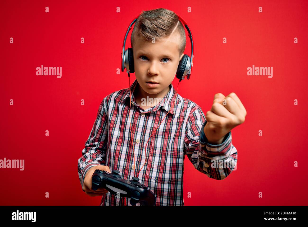 Young little caucasian gamer kid playing video games using gamepad ...
