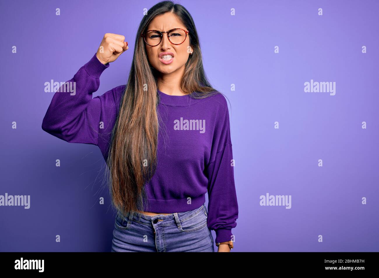 Young beautiful smart woman wearing glasses over purple isolated ...