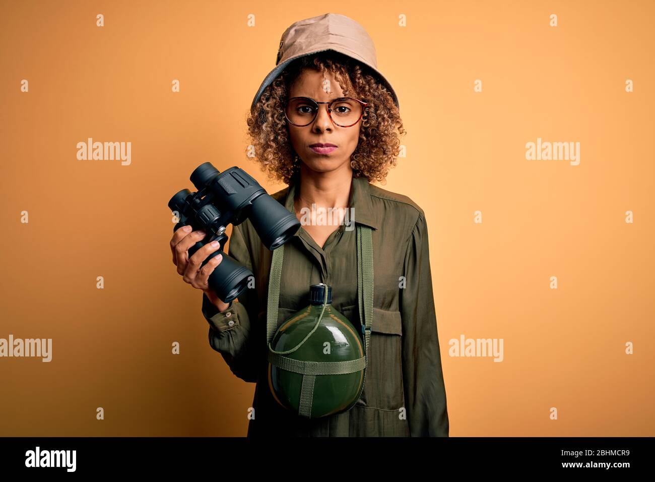 African american tourist woman wearing explorer hat and water canteen ...