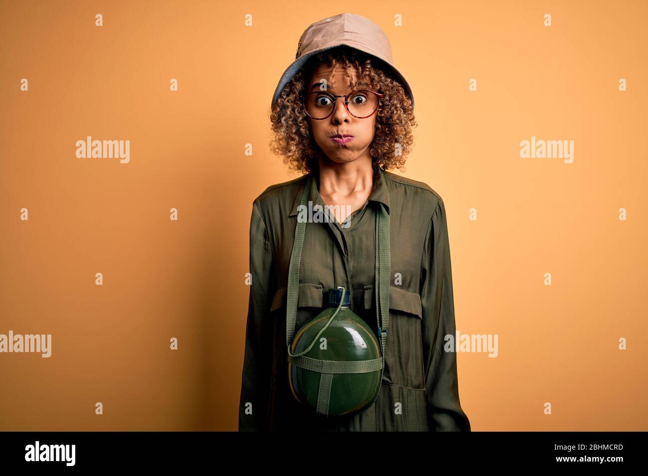 Young african american tourist woman on vacation wearing explorer hat ...