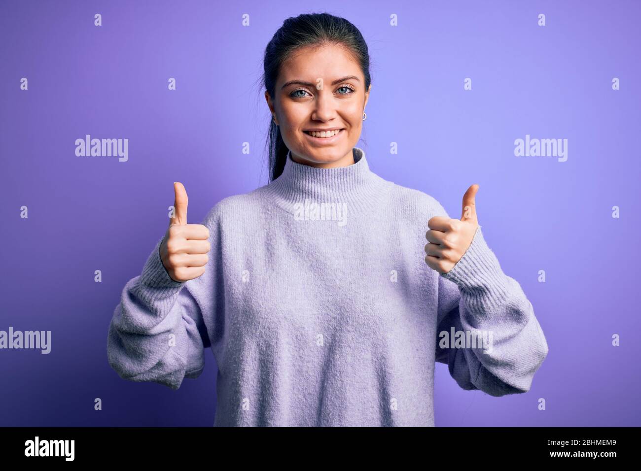 Young beautiful woman with blue eyes wearing casual turtleneck sweater ...