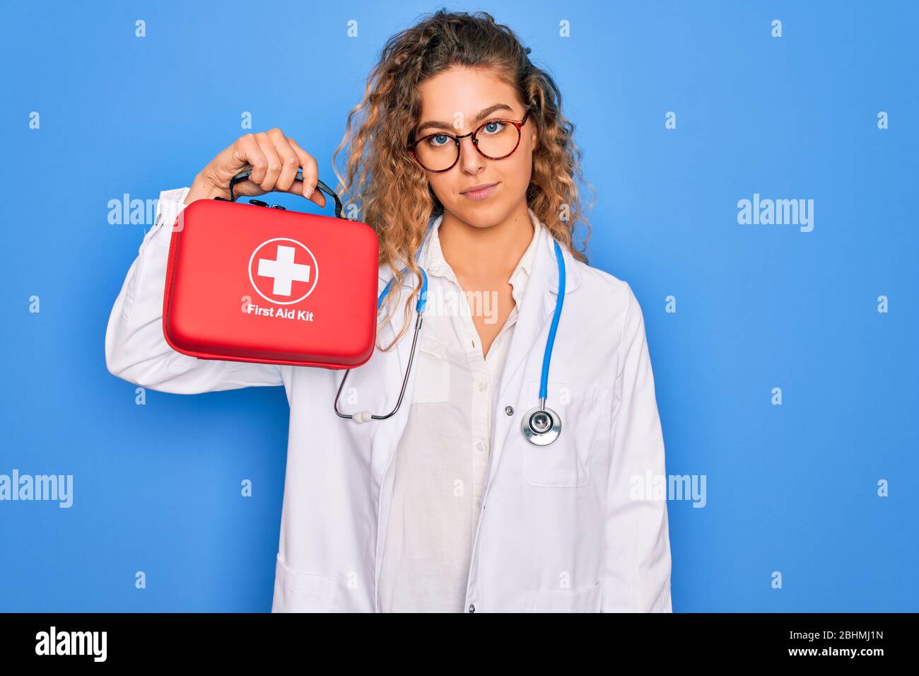 Young beautiful blonde doctor woman with blue eyes wearing stethoscope ...