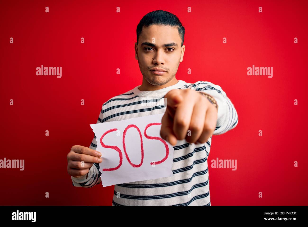 Young brazilian man with problem holding banner with sos message over ...