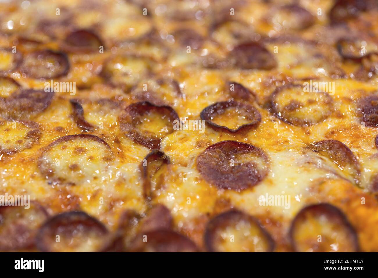 Close up texture of large cheesy pepperoni pizza, background macro