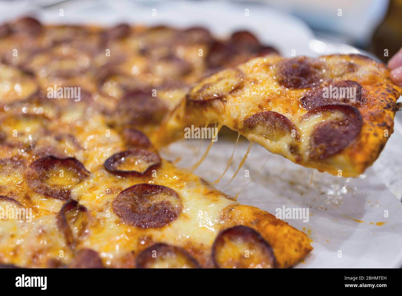 Close up texture of large cheesy pepperoni pizza, background macro