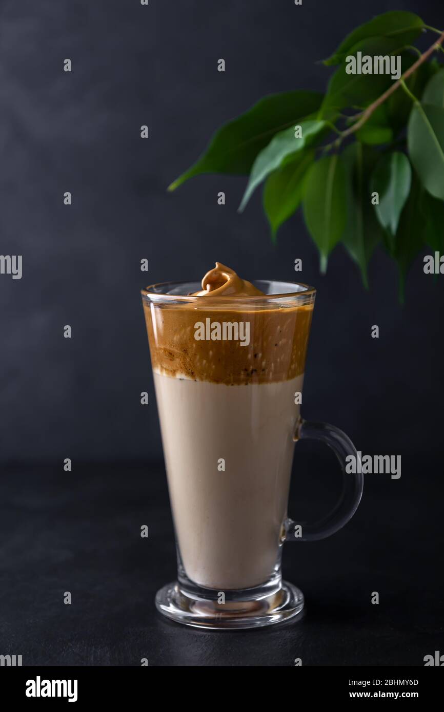 Dalgon coffee in a glass cup on a black background. Korean drink with milk and whipped coffee Stock Photo