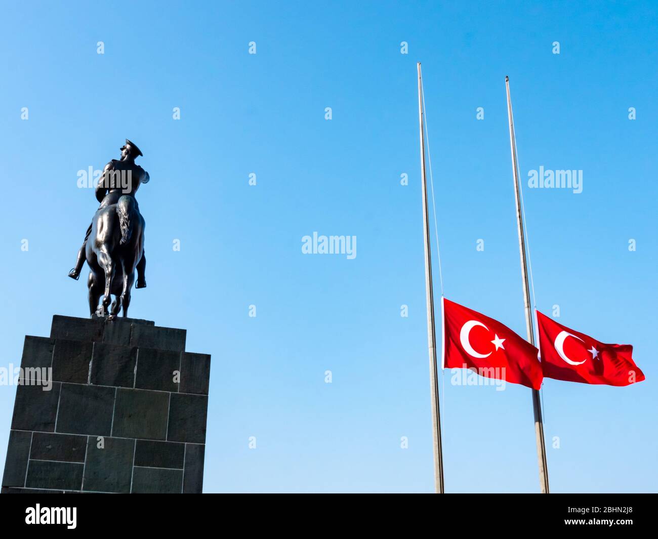 Mustafa Kemal Ataturk riding horse sculpture silhouette and Turkish flag, lower the flag to half-staff in 10 november. Stock Photo